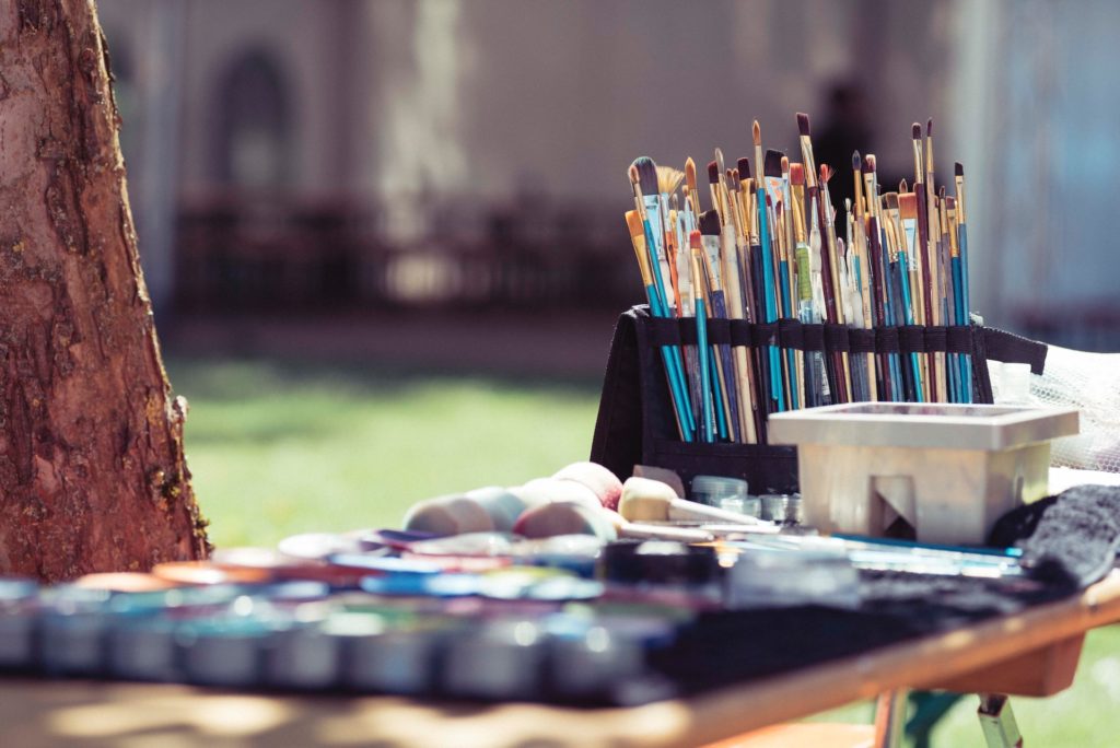 paintbrushes and paint displayed on a table outside